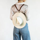 Backpack Style shown wearing the Sidecar The OG 14K gold hat clip with genuine brown leather side strap, white stitching, and adjustable leather strap with 14k hardware. Luxury, hands-free hat carry worn in 4 styles: Crossbody, Backpack, Purse-style, and Waist-wear.