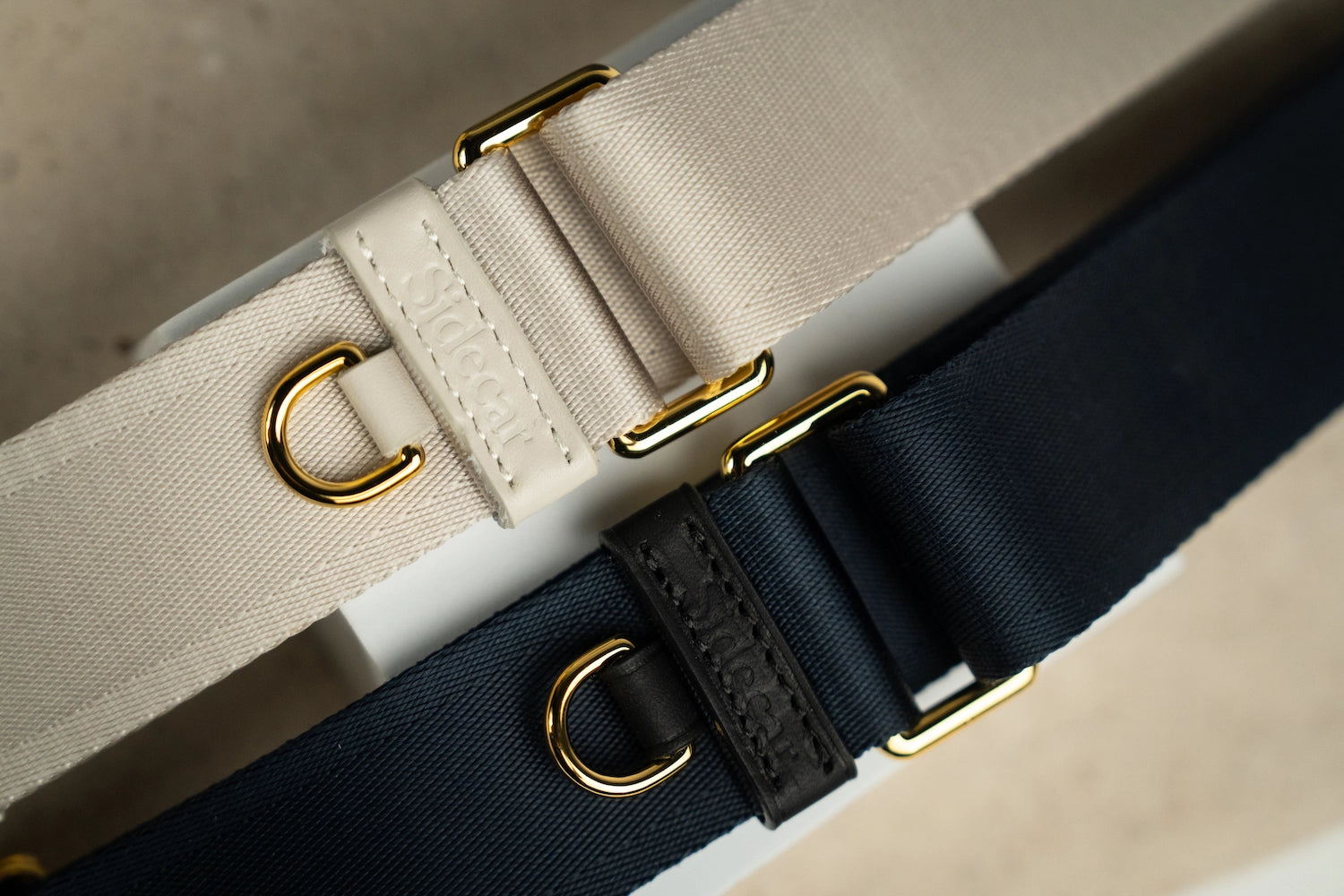 Sidecar black sable and stone neutral nylon purse strap, featuring a smooth durable design, gold accents, and adjustable length for bags. Luxurious and durable.