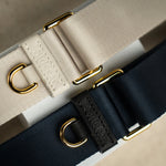 Sidecar black sable and stone neutral nylon purse strap, featuring a smooth durable design, gold accents, and adjustable length for bags. Luxurious and durable.