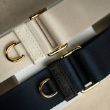 Sidecar black sable and stone neutral nylon purse strap, featuring a smooth durable design, gold accents, and adjustable length for bags. Luxurious and durable.