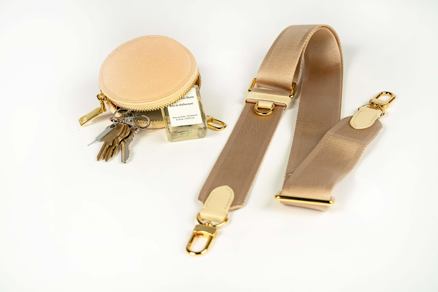 Sidecar buttercream dark neutral nylon purse strap, featuring a smooth durable design, gold accents, and adjustable length for bags. Matching buttercream dark neutral round coin purse with gold accents. Hands-free, secure carry.