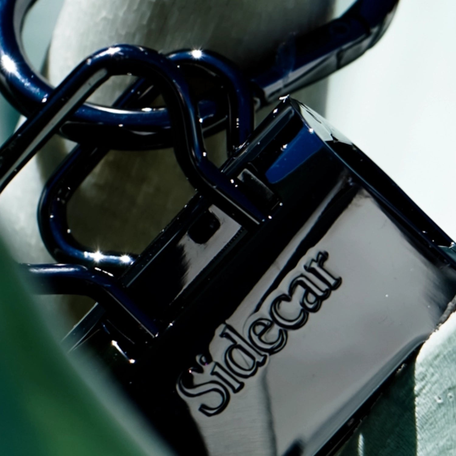 Sidecar Shiny Black Duo Set. Close-up of oval hinge clasp and patented hat-safe tension system. 

Sidecar Duo Set holds a hat securely for hands-free travel.