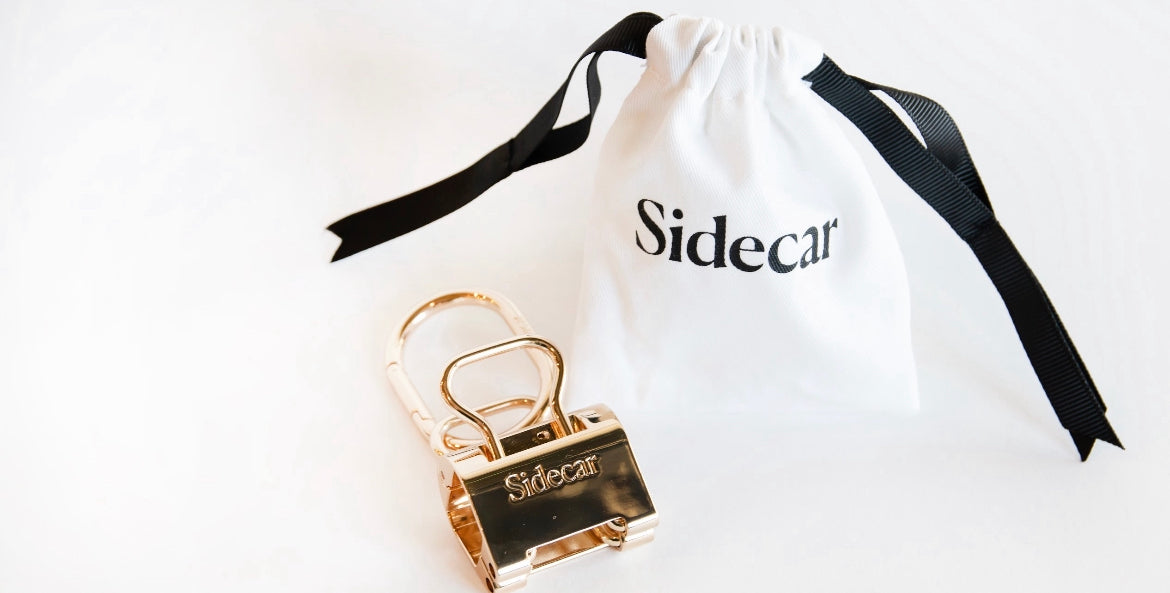 Sidecar Premium 14k Gold Duo Set and Sidecar soft, white storage bag. 

Sidecar 14K Gold Duo Set with 14K Gold Hardware. Close-up of oval hinge clasp and patented hat-safe tension system. Secure, durable, hands-free hat carry, luxurious, 14K gold metal.