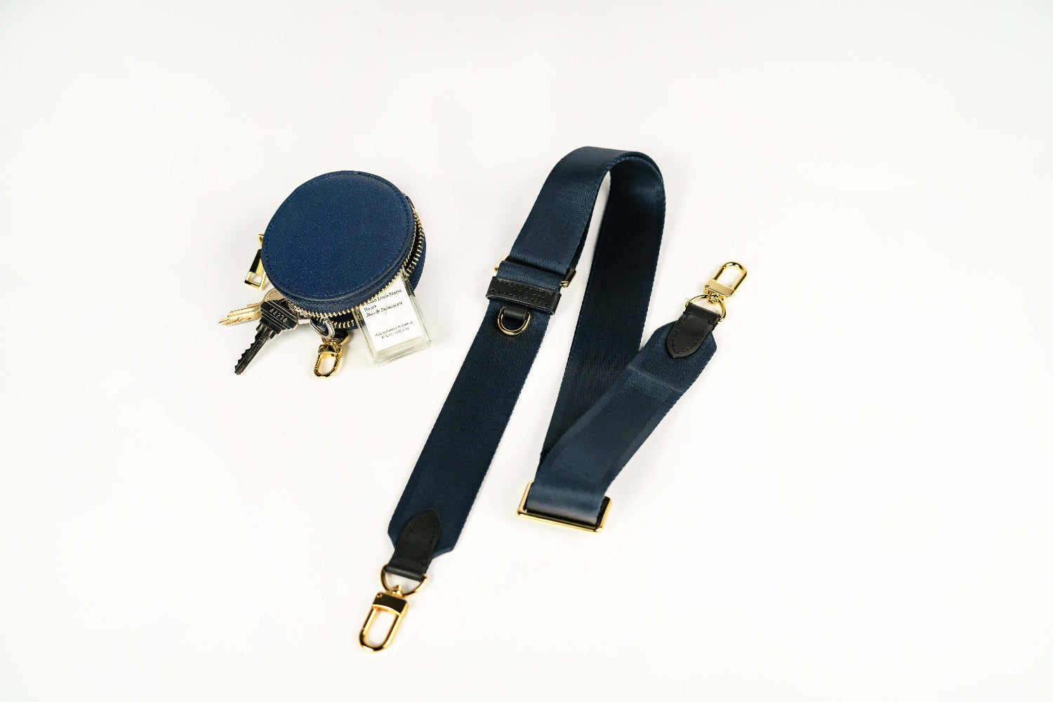 Sidecar indigo blue nylon purse strap, featuring a smooth durable design, gold accents, and adjustable length for bags. Matching indigo blue round coin purse with gold accents. Hands-free, secure carry.