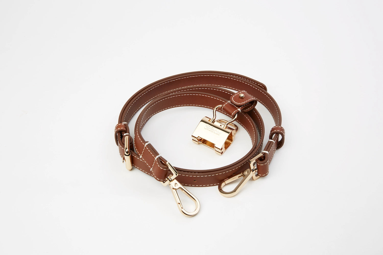 Sidecar The OG 14K gold hat clip with genuine brown leather side strap, white stitching, and adjustable leather strap with 14k hardware. Luxury, hands-free hat carry worn in 4 styles: Crossbody, Backpack, Purse-style, and Waist-wear.