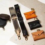 Sidecar ID envelopes with premium leather finish and snap closure, designed to securely hold identification and small essentials. Sidecar black and olive coin purse. Sidecar black and olive nylon purse straps. Hands-free carry, worry-free carry.