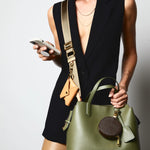 Sidecar olive green nylon purse strap, featuring a smooth durable design, gold accents, and adjustable length for bags. Matching ID envelope with premium leather finish and snap closure, designed to securely hold identification and small essentials. Matching round coin purse with gold accents. Hands-free, secure carry.