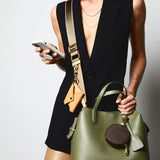 Sidecar olive green nylon purse strap, featuring a smooth durable design, gold accents, and adjustable length for bags. Matching ID envelope with premium leather finish and snap closure, designed to securely hold identification and small essentials. Matching round coin purse with gold accents. Hands-free, secure carry.